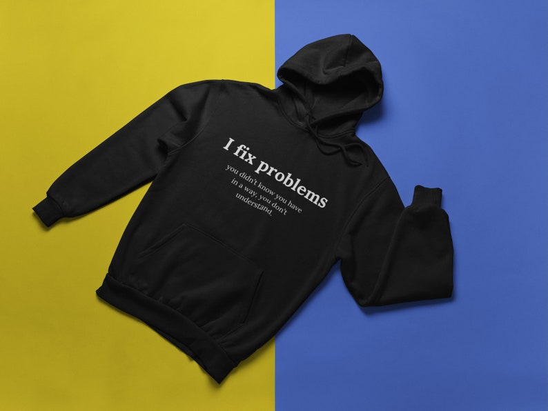 May include: Black hooded sweatshirt with the text "I fix problems you didn't know you have in a way, you don't understand." printed in white on the front.