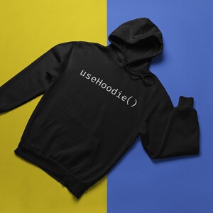 May include: Black hoodie with a white text design that says "useHoodie()" on a yellow and blue background.