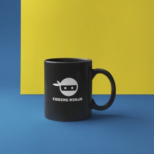 Pu&ograve; includere: Tazza in ceramica nera con grafica ninja bianca e la scritta "CODING NINJA". La tazza ha un manico curvo ed &egrave; posta su uno sfondo blu e giallo.