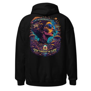 Könnte beinhalten: Schwarzer Kapuzenpullover mit einem farbenfrohen Grafikdruck auf dem Rücken. Das Design zeigt eine Frau mit Sonnenbrille, umgeben von Pilzen, mit dem Text "CATSONDRUGS.COM", "TECHNO", "RAVE" und "STEP THROUGH THE GATE".