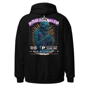 May include: Black hooded sweatshirt with a graphic print of a blue monster with glowing eyes and the text "Paranoid" in purple letters. The graphic also includes a star, a globe, and the text "Afterhour Techno Rave" and "Berlin".