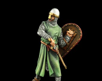 Puede incluir: Una figurita de metal pintada a mano de un caballero medieval que lleva una armadura de malla, una túnica verde y un casco con protección para la nariz. Sostiene una espada y un escudo con un diseño rojo y dorado. La figurita está de pie sobre una base rocosa.