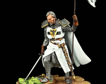 May include: A hand-painted miniature figure of a knight in white armor, holding a sword and a white flag with a black and gold eagle emblem. The knight is standing on a green and brown base.