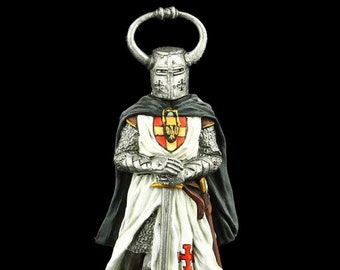 Könnte beinhalten: Eine Zinnfigur eines Ritters in voller Rüstung, der eine weiße Tunika mit einem roten Kreuz und einen schwarzen Umhang trägt. Der Ritter hält ein Schwert und trägt einen Helm mit einem gehörnten Kamm.
