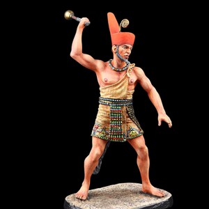 Könnte beinhalten: Detaillierte Figur eines altägyptischen Kriegers, der bereit ist, mit einer goldenen Keule zuzuschlagen. Die Figur trägt eine rote Kopfbedeckung, eine Perlenkette und einen gemusterten Rock. Der Krieger steht auf einem rechteckigen Sockel.