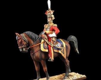 May include: A detailed miniature figurine of a soldier in a red uniform riding a brown horse. The soldier wears a tall hat with a white plume. The horse has a decorative saddle blanket with blue and gold accents. The figurine is mounted on a rectangular base.