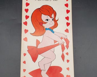 May include: Vintage Valentine's Day card featuring a cartoon cupid with red hair, a blue necklace, and a large red bow. The card is bordered with red hearts and includes the text "I KNOW WHAT YOU WANT FOR VALENTINE'S DAY."