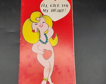 May include: Vintage Valentine's Day card with a cartoon illustration of a woman with blonde hair and a heart-shaped body. The card is red with the text "I'LL GIVE YOU MY HEART!" in a white heart-shaped speech bubble.