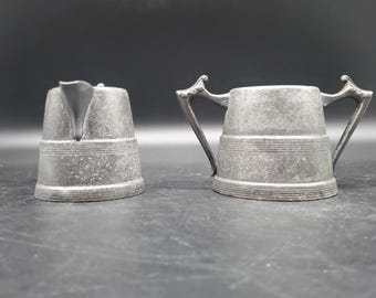 Juego de jarro pequeño de peltre antiguo para crema y azúcar con doble asa.