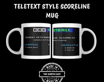 May include: White ceramic mug with a black and blue design. The mug features a teletext-style scoreboard with the text "BBC Football" and the date "Sunday 16th March". The scoreboard shows the results of a football match between Liverpool and Newcastle.