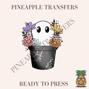 May include: A white ghost with black eyes and a floral crown sits in a black pot with a spiderweb design. The image includes the text "PINEAPPLE TRANSFERS" and "READY TO PRESS". A cartoon pineapple with sunglasses is in the bottom right corner.