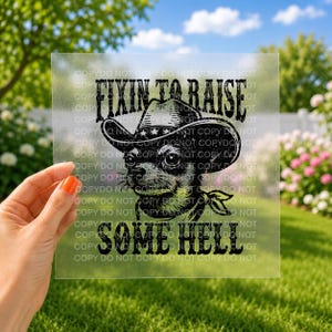 May include: A clear transfer sheet featuring a black graphic illustration of a chihuahua wearing a cowboy hat with a bandana around its neck. The text FIXIN TO RAISE SOME HELL is printed in a bold, distressed font above and below the dog.
