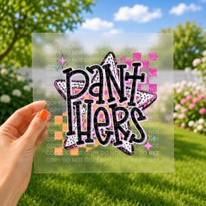 May include: A square, transparent decal featuring a large, stylized star with a black and white polka dot pattern. The word PANTHERS is written in bold, black, outlined letters across the star. The design includes orange and pink checkered accents.