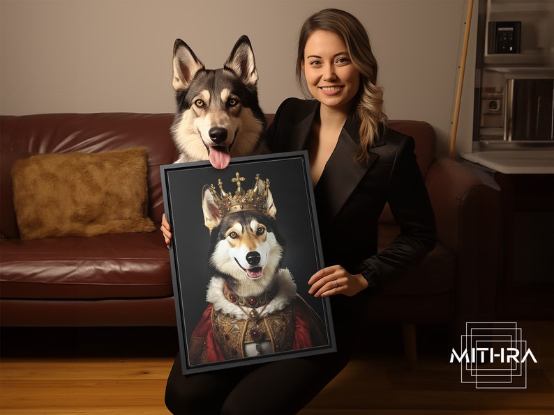 May include: A woman holds a framed portrait of a dog wearing a gold crown and a red and gold robe. The dog is looking directly at the camera with a happy expression. The portrait is set against a dark background.