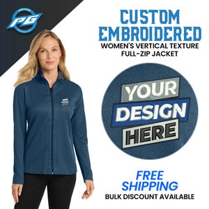 May include: A blue full-zip jacket with a vertical texture. The jacket has a mock neck and a zipper closure. The text "YOUR DESIGN HERE" is embroidered on the jacket.