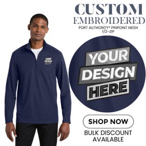 May include: Navy blue 1/2-zip Port Authority pinpoint mesh shirt with custom embroidery. The shirt features the text "YOUR DESIGN HERE" embroidered on the chest and a larger version on a navy blue circle.