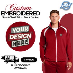 May include: A red and white track jacket with a zipper closure. The jacket has a white stripe down each sleeve and a white collar. The text "YOUR DESIGN HERE" is embroidered on the jacket.