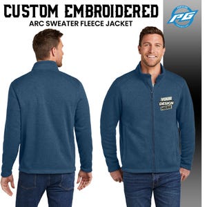 Puede incluir: Una chaqueta de forro polar azul con cierre de cremallera y cuello alto. La chaqueta tiene un bolsillo en el lado izquierdo y el texto "YOUR DESIGN HERE" est&aacute; bordado en el lado derecho.