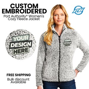 May include: A white and black fuzzy fleece jacket with a zipper closure. The jacket has a patch on the left chest that says "YOUR DESIGN HERE".