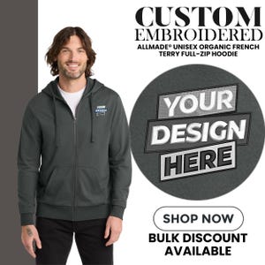 May include: A dark gray unisex full-zip hoodie with a hood and front pockets. The hoodie has the text "YOUR DESIGN HERE" on a circular graphic. The image also includes the text "CUSTOM EMBROIDERED" and "SHOP NOW".