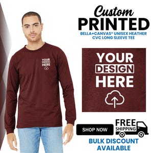 May include: A maroon long-sleeve tee with the text "YOUR DESIGN HERE" and a cloud graphic. The shirt is part of a custom printed apparel line, with the text "Custom PRINTED" at the top. The shirt is made of Bella+Canvas unisex heather CVC material.
