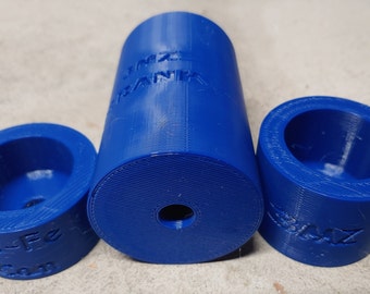 Pode incluir: Três objetos azuis impressos em 3D. A peça central é cilíndrica com o texto "LINZ BANK" na lateral. Duas peças circulares menores a ladeiam, cada uma com o texto: "Bs-Fe Co." e "BLAZ Z". Todas as peças têm uma superfície texturizada.