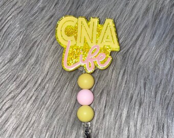 May include: Yellow and pink beaded retractable badge holder with a yellow glitter charm that says "CNA Life".