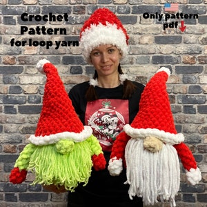 May include: Two crocheted gnomes wearing red and white Santa hats. The gnomes have white beards and green and white hair. The gnomes are being held by a person wearing a black shirt with a Christmas design. The text "Only pattern pdf" is in the top right corner of the image.