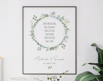 May include: A framed print with a black border, featuring a circular design of green leaves and text in German. The text reads "Zwei Menschen, Eine Zukunft, Zwei Seelen, Ein Traum, Zwei Herzen, Eine Liebe." Below the circle are names and a date.