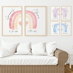 Könnte beinhalten: Gerahmte Aquarelldrucke mit Regenbogenmotiven in Pastelltönen. Jeder Druck enthält einen Namen und ein Datum. Die Drucke werden über einem weißen Sofa mit weißen Kissen präsentiert, was eine beruhigende Ästhetik schafft.