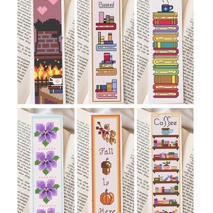May include: Six different cross-stitch bookmark designs. The designs include a fireplace with a cup of coffee, a stack of books with the text "My day is fully booked", a stack of books with a cup of coffee and a heart, a row of purple flowers, a pumpkin, acorn, and mushroom with the text "Fall is here", and a bookshelf with books and the text "Coffee and books".