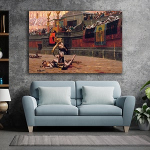 May include: A framed canvas print depicting a historical scene of gladiators in an arena. The artwork features a gladiator in gold armor standing over a fallen opponent, with a crowd in the background. The color palette includes browns, reds, and golds.