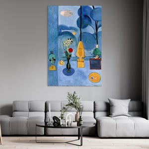 May include: A vertical abstract painting in shades of blue. It depicts a table with a vase of flowers, a lamp, and other decorative objects. The artwork has a modern, minimalist style.