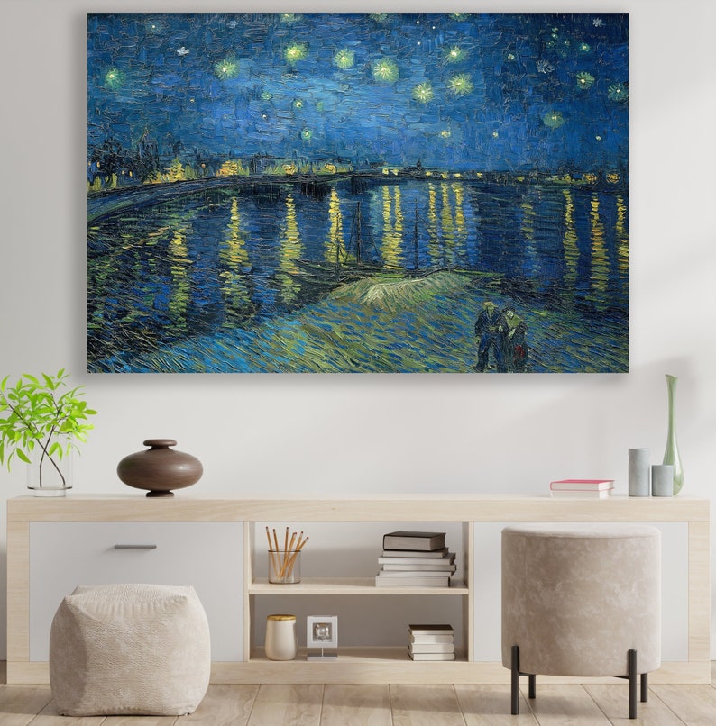 May include: A painting of a starry night sky over a river with a town in the distance. The river is reflecting the lights of the town and the stars in the sky. Two figures are standing on the bank of the river in the foreground.