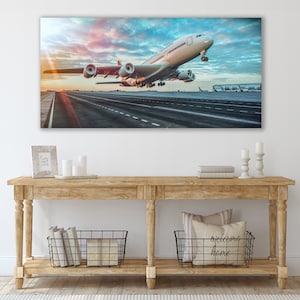 May include: A white airplane taking off from a runway with a cloudy sky in the background.