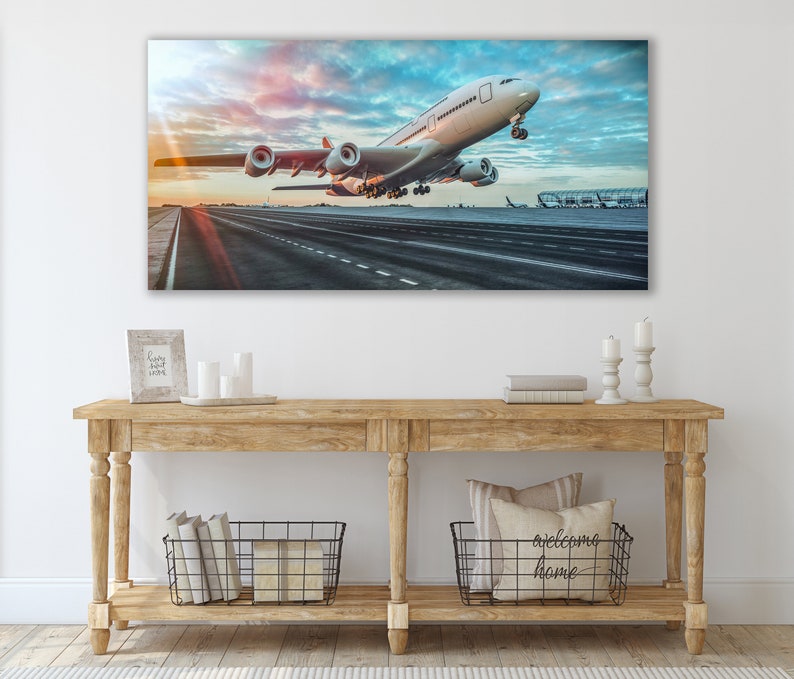 May include: A white airplane taking off from a runway with a cloudy sky in the background.