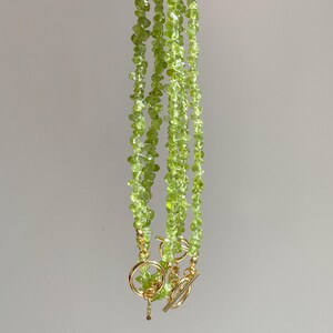 May include: A set of three green gemstone necklaces with gold clasps. The necklaces are made of small, irregular shaped green stones.