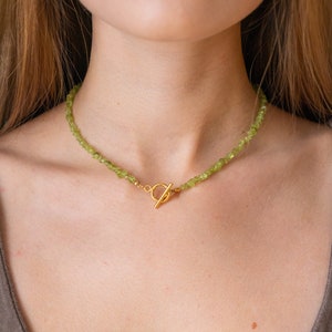 Green peridot choker necklace with small gemstones and a golden toggle closure