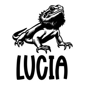 May include: Black and white illustration of a bearded dragon lizard with the name "Lucia" in bold letters below. The lizard is depicted in a detailed, stylized manner, with sharp claws and textured skin.