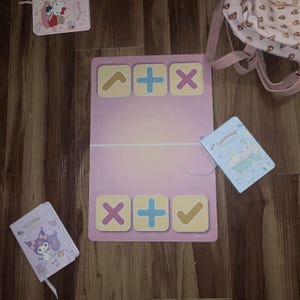 Puede incluir: Colección de artículos de papelería, que incluyen cuadernos y una alfombra rosa y morada con símbolos matemáticos. Los cuadernos presentan personajes de dibujos animados. También se ve una mochila rosa claro.