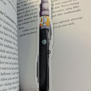 Peut inclure: Une illustration en noir et blanc d'une cigarette électronique avec un design coloré. La cigarette électronique est un marque-page avec un fond blanc.