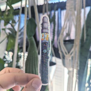 Peut inclure: Un autocollant de stylo vape noir et blanc avec des paillettes.