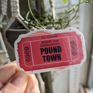 May include: A red and white ticket with the text "B.S. Express. Admit one. Destination: POUND TOWN" and the number "6969" on each side.