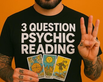 May include: A black t-shirt featuring the white text 3 QUESTION PSYCHIC READING printed above an illustration of three tarot cards. The cards depict a compass, a sun with a face, and a figure standing on a cliff edge with the word FOOL visible.