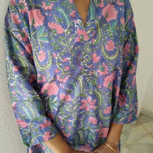 May include: A blue and pink floral print tunic top with a V-neck and three-quarter sleeves.