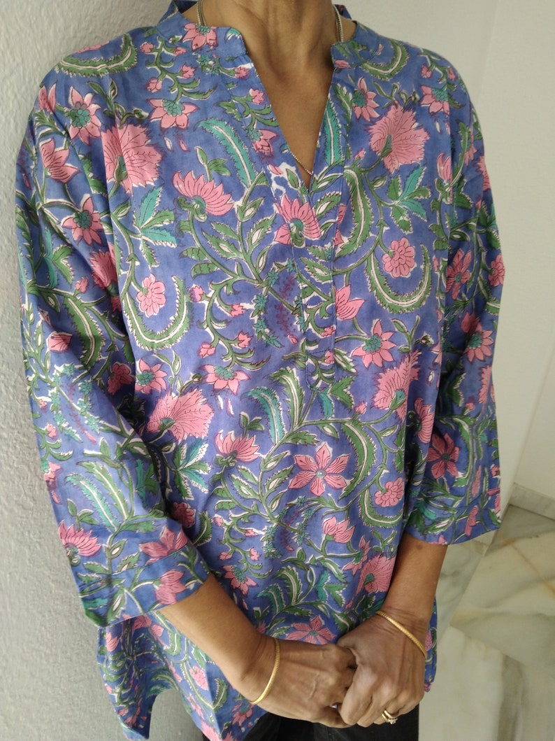 May include: A blue and pink floral print tunic top with a V-neck and three-quarter sleeves.