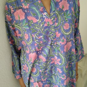 May include: A blue and pink floral print tunic top with a V-neck and 3/4 sleeves.