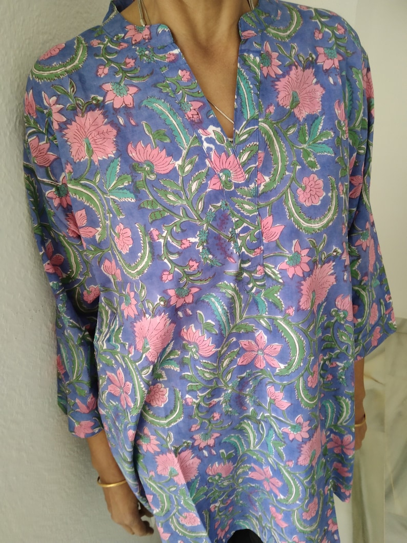 May include: A blue and pink floral print tunic top with a V-neck and 3/4 sleeves.