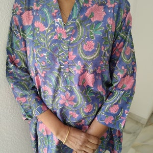 May include: A blue and pink floral print tunic top with a V-neck and long sleeves.