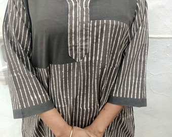 May include: A dark gray tunic with a mandarin collar and a V-neckline. The tunic features a vertical striped pattern in white and dark brown. The sleeves are three-quarter length. The top is a loose fit.